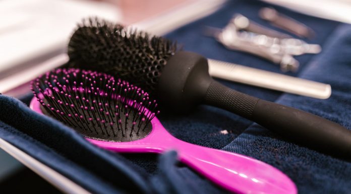 ÚLTIMA HORA: Guía de más de 30 expertos en belleza en Jersey City Close-up of pink and black hairbrushes on a towel in a salon setting.