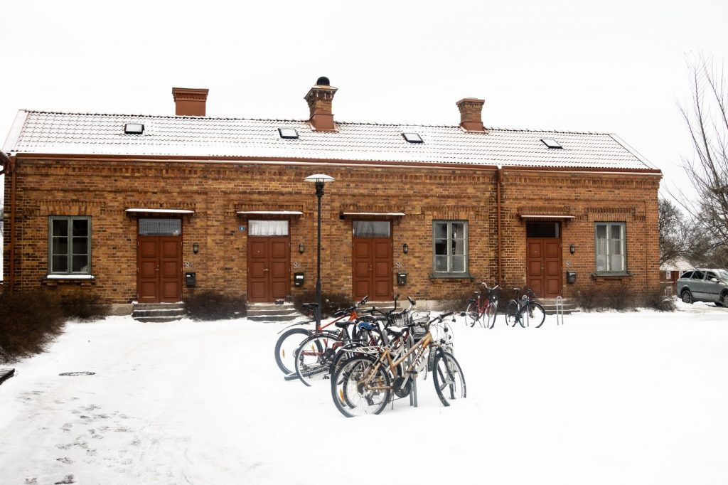 Bicycles parked in front of a snow-covered brick building in Jönköping, Sweden.