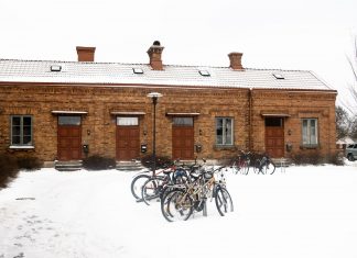 Bicycles parked in front of a snow-covered brick building in Jönköping, Sweden.