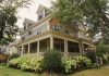 ÚLTIMA HORA: Rechazan subdivisión de propiedad histórica en Jersey City Charming traditional house with a wraparound porch, surrounded by lush garden.