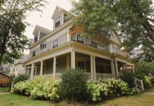 ÚLTIMA HORA: Rechazan subdivisión de propiedad histórica en Jersey City Charming traditional house with a wraparound porch, surrounded by lush garden.