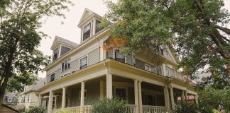 ÚLTIMA HORA: Rechazan subdivisión de propiedad histórica en Jersey City Charming traditional house with a wraparound porch, surrounded by lush garden.