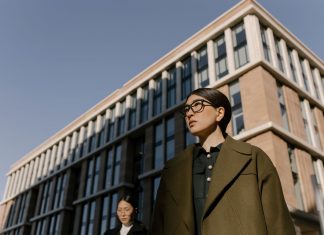 ÚLTIMA HORA: Restrepo & Associates nombra a James Barnett vicepresidente Two stylish women in coats in a business district with modern architecture.