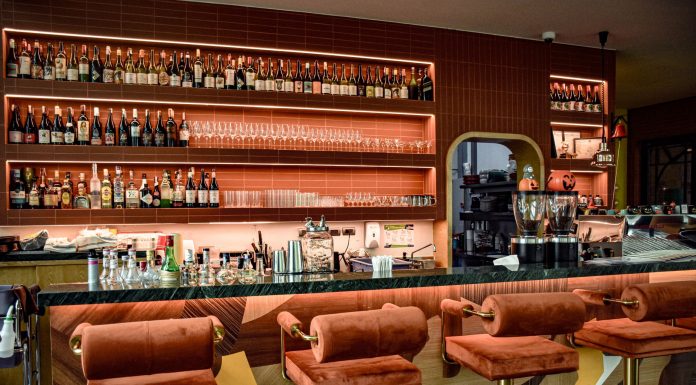 ÚLTIMA HORA: Tu bar en Hoboken según tu signo zodiacal A chic bar interior showcasing a sophisticated design with plush seating and a well-stocked counter.