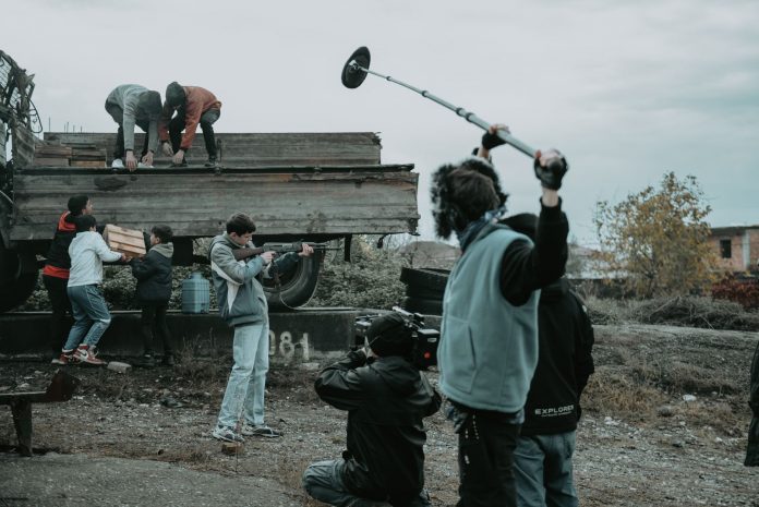 ltima-hora-willem-dafoe-filma-late-fame-en-jersey Film crew working outdoors, capturing scenes with camera and boom mic.