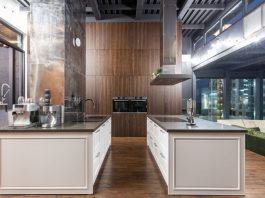 Interior of contemporary spacious kitchen with stylish furniture in apartment with loft style