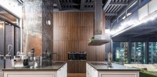 Interior of contemporary spacious kitchen with stylish furniture in apartment with loft style