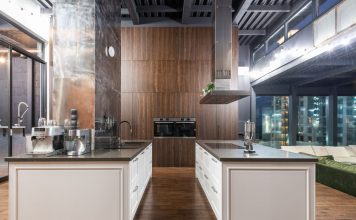 Interior of contemporary spacious kitchen with stylish furniture in apartment with loft style