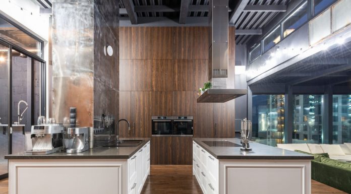 Interior of contemporary spacious kitchen with stylish furniture in apartment with loft style
