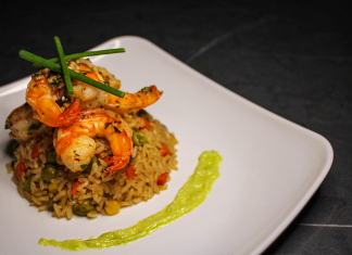 Guía 2026 para Disfrutar la Mejor Comida Colombiana en Elizabeth, NJ Savory prawn fried rice garnished with chives on a stylish white plate, capturing gourmet cuisine.