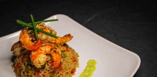 Guía 2026 para Disfrutar la Mejor Comida Colombiana en Elizabeth, NJ Savory prawn fried rice garnished with chives on a stylish white plate, capturing gourmet cuisine.