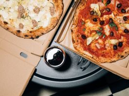 Top view of delicious pizzas in boxes with a refreshing drink, perfect for a cozy meal.