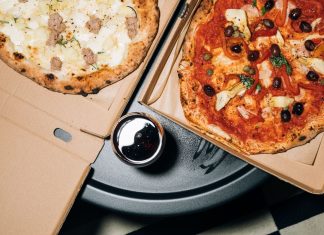 Top view of delicious pizzas in boxes with a refreshing drink, perfect for a cozy meal.