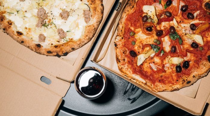 Top view of delicious pizzas in boxes with a refreshing drink, perfect for a cozy meal.