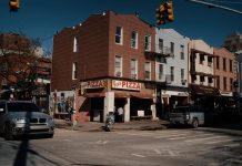 La Mejor Pizza en West New York en 2026: Guía Definitiva de las Pizzerías Imperdibles Street view of Joe's Pizza on a sunny day in Brooklyn, showcasing the lively urban atmosphere.