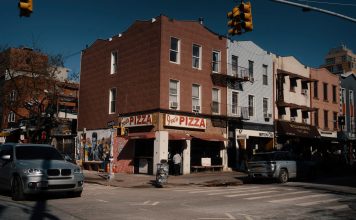 La Mejor Pizza en West New York en 2026: Guía Definitiva de las Pizzerías Imperdibles Street view of Joe's Pizza on a sunny day in Brooklyn, showcasing the lively urban atmosphere.