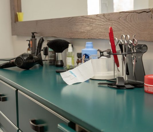 A well-organized salon workspace featuring essential hair styling tools on a cabinet.