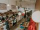 Bright and inviting coffee shop interior with people working, featuring stylish decor and pendant lighting.