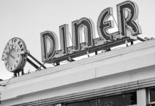 Los Mejores Desayunos en Bayonne (2026): Guía Local de los Imperdibles Black and white photo of a vintage diner sign with a clock in Somerville, MA.