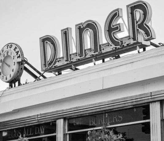 Los Mejores Desayunos en Bayonne (2026): Guía Local de los Imperdibles Black and white photo of a vintage diner sign with a clock in Somerville, MA.