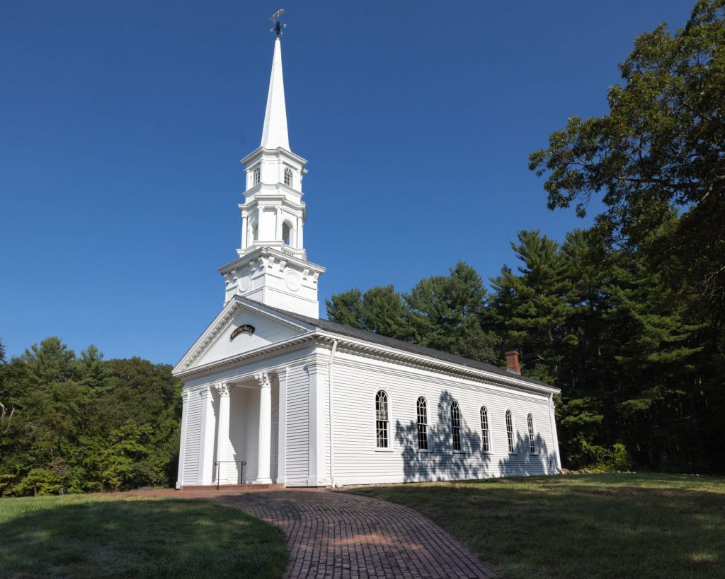 Charming white church with steeple surrounded by trees in Sudbury, Massachusetts.