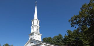 Charming white church with steeple surrounded by trees in Sudbury, Massachusetts.