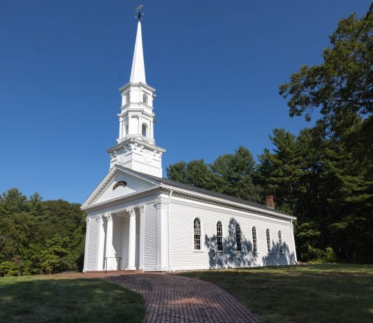 Charming white church with steeple surrounded by trees in Sudbury, Massachusetts.