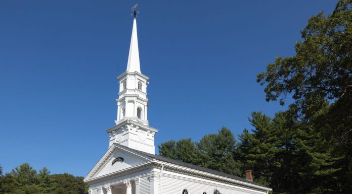 Charming white church with steeple surrounded by trees in Sudbury, Massachusetts.