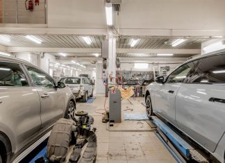Los Mejores Talleres Mecánicos en Hoboken: Guía Completa 2026 Interior of an automotive repair shop with cars undergoing maintenance and servicing.