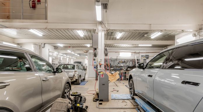 Interior of an automotive repair shop with cars undergoing maintenance and servicing.