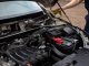 Mechanic inspecting car engine bay and battery during routine maintenance.