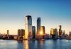 Breathtaking sunrise view over New York City skyline with reflection on the water.