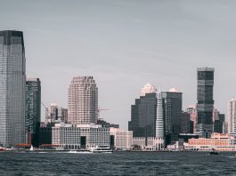 A breathtaking view of Jersey City's skyline from across the Hudson River with modern skyscrapers and waterfront buildings.