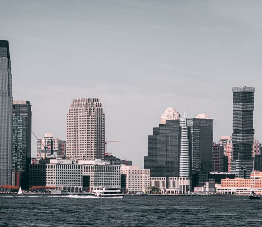 A breathtaking view of Jersey City's skyline from across the Hudson River with modern skyscrapers and waterfront buildings.