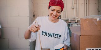 A cheerful volunteer serving food at a donation center, symbolizing generosity and community support.