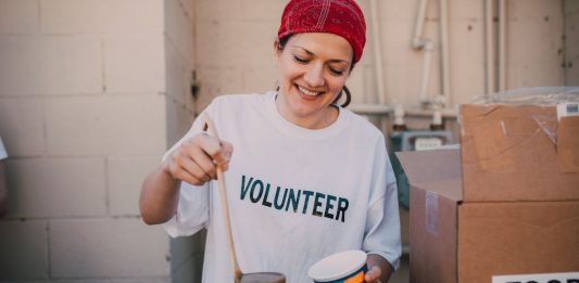 A cheerful volunteer serving food at a donation center, symbolizing generosity and community support.
