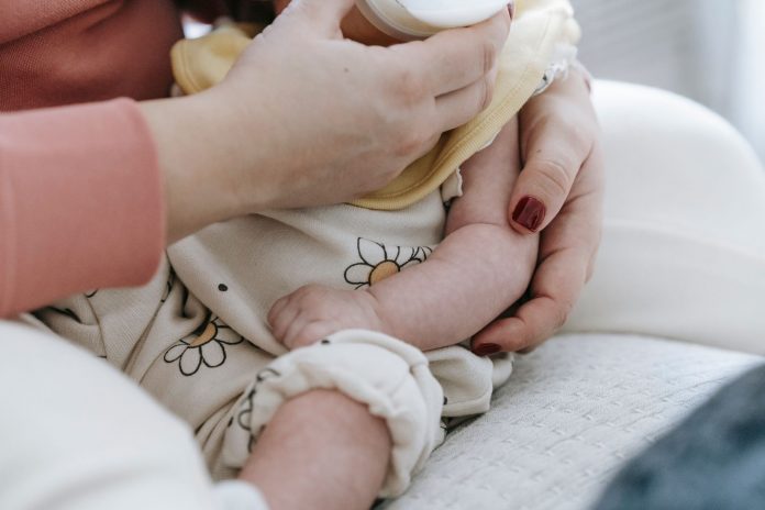 new-hoboken-lactation-center-aims-to-fill-gaps-in- Crop anonymous mother embracing and feeding adorable newborn baby with milk from bottle at home