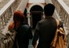 NJCU Officially Becomes Kean Jersey City: What It Means for Students and the Community Two university students with backpacks walk down a grand staircase in a historic building.