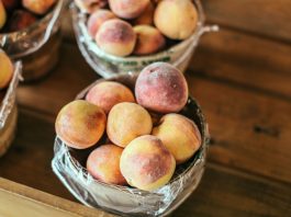 A collection of fresh peaches stacked in baskets, highlighting their juicy appeal and rustic setup.
