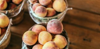 A collection of fresh peaches stacked in baskets, highlighting their juicy appeal and rustic setup.
