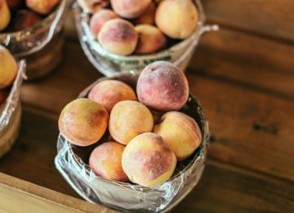 A collection of fresh peaches stacked in baskets, highlighting their juicy appeal and rustic setup.