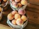 A collection of fresh peaches stacked in baskets, highlighting their juicy appeal and rustic setup.
