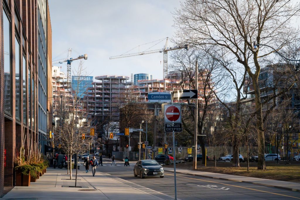 Urban construction site in downtown Toronto with cranes and modern architecture.
