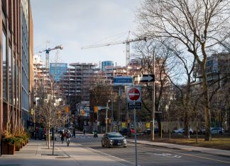 Urban construction site in downtown Toronto with cranes and modern architecture.