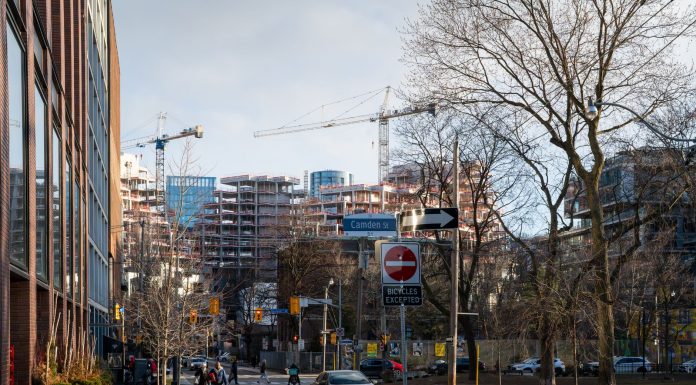 Urban construction site in downtown Toronto with cranes and modern architecture.