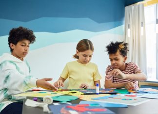 Guía Completa de Programas Extraescolares en Union City (2026) Children focusing on an art project with colored papers in a playful art class setting.
