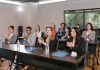 A diverse group of adults applauding in a business seminar setting.