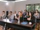 A diverse group of adults applauding in a business seminar setting.