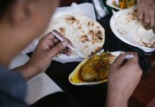 Crop anonymous person eating tasty meat with vegetables and pita for dinner in cafe