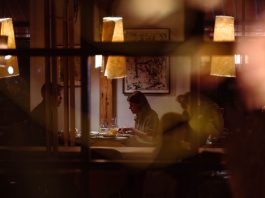 Romantic dining scene in a cozy restaurant with warm lighting and intimate atmosphere.